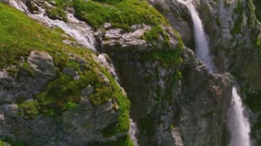Güzel bir şelalenin havadan çekilmiş fotoğrafı. Kamera aşağıya bakıyor. Kafkasların yüksek dağlarında, sarp kayalıklardan düşen su damlaları..