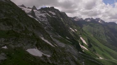 Kayalık bir yamaçta kayalıklar, derin çatlaklar ve Kafkas Dağları 'nın kayalıklarında küçük şelaleler var. Dağ vadisi manzarası.