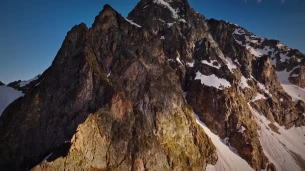 夕阳西下 空中俯瞰高山 俯瞰一座高耸的山巅 高对比度 稳定的镜头从空中拍摄 早春的山脉 — 图库视频影像
