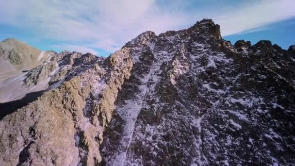 阳光明媚的一天 一只飞翔的小鸟爬上高山上的一块史诗般的岩石 镜头是在一个运动Fpv无人驾驶四联直升机上拍摄的 岩石密布的跨距 — 图库视频影像