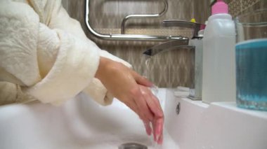 Akan suyun altında polimer hizalayıcının yakın çekimi. Kafkas bir kadının elleri ısırığı düzeltmek için hizayı duruluyor. Ağız temizliği..
