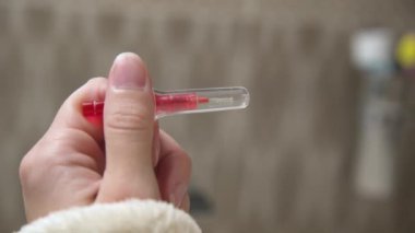 Lavabonun arka planında dişler arası fırçayla kadın ellerine yakın çekim. Diş telleri ve diş telleri için profesyonel bakım.