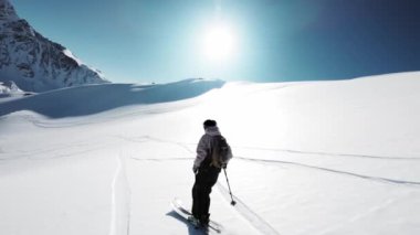 İnsansız hava aracı tarafından yavaş çekim. Çarpıcı kayakçı resimli dağlarda kayak yaparken taze karı ezer. Aktif bir erkek turistle uçmak nefes kesen bakir topraklarda kayak yapmak.