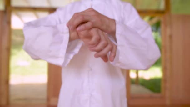 Beyaz Elbiseli Beyaz Tenli Beyaz Bir Erkek Qigong Antrenmanına Hazırlanıyor — Stok video