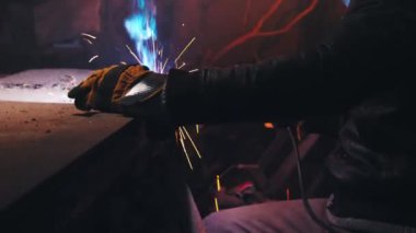 Metal kaynakçı evde çelik kaynak yapmak için yay kaynakçısıyla çalışır, güvenlik ekipmanları kullanır. Evde metal yapıların onarımı ve üretimi.