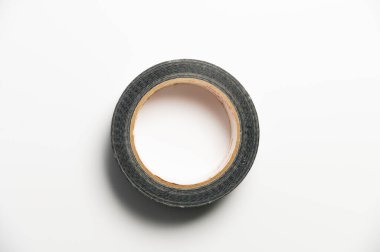 Çatıyı beyaz bir arka plan üzerine kurarken, çatı malzemelerinin eklemlerini mühürlemek için siyah takviyeli bir bant rulosu..