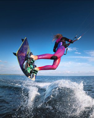 professional kiter performs a difficult trick on a beautiful background with splashes of water from the sea and a cloudy sky. clipart