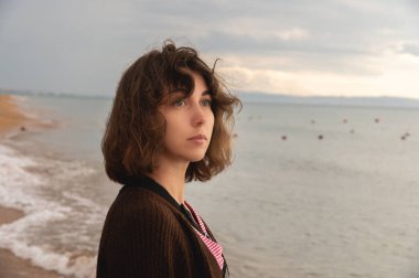 Genç kadın kavramı ve duygular. Açık havada özgürlüğün ve hislerin tadını çıkaran bir kadının iç dengeli portresi. Gezmeye ve gezmeye hevesli bir kız. Kıvırcık saçlı güzel bayan.