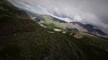 FPV, yırtıcı bir kartalın ya da vahşi bir akbabanın yanında uçuyor. Dağların tepesinde, hasta bir yırtıcı kuşu takip eden havadan bir görüntü. Yavaş çekim.