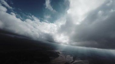 Bulutların üzerinde gündüz güneşiyle uçan hava manzarası. Güzel yansımalarla hareket eden bulutların arasında uçmak. Hava yolculuğu. Sinema ve arka plan için ideal.