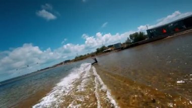 Kiteboardcu, FPV yarış aracından yavaş çekimde atlamaya çalışıyor. Suyun altındaki seksi sporcu kadın..