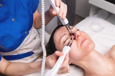 Ultrasonik yüz tedavisi ultrason yüz makinede. Elektrikli Asansör masaj spa salonu çekici bir kadın. Stimülasyon kasları profesyonel ekipman microcurrent terapisi. Gençleştirme yeni yöntemler.
