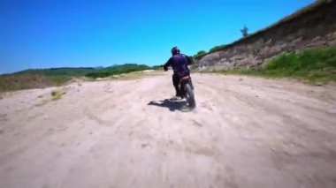 FPV İHA 'dan hava görüntüsü. Profesyonel bir motokrosçunun FMX motosikletini sürdüğü bir sonraki fotoğraf..