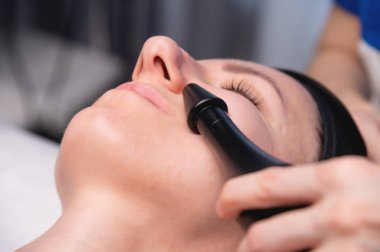 Şevval Özçelik Güzellik el ultrason yüz yordam tarafından özel ekipman yapmadan kapatın. Kapalı gözleri hafif gülümsemeyle.