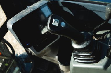 Taksideki küçük bir kazıcının kontrolü. Özel ekipman teması için arkaplan.