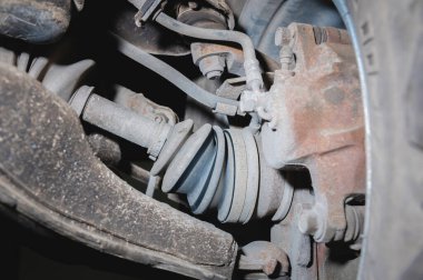 Ön tekerden çekiş aracının kirli kullanılmış süspansiyonunu içeriden izle. CV ekleminde yarı sürücü ve fren ayarlı açı.