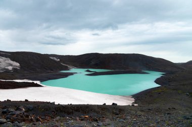 Volkanik kayalar ve eriyen buzullarla çevrili bir turkuaz göl. Küresel ısınma ve gezegendeki cansız yerler.
