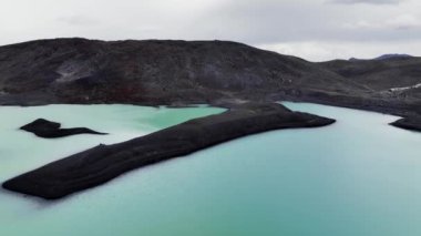 Eriyen buzulu ve volkanik külleri olan alp cansız gölü. İzlanda, bulutlu bir günde turkuaz göl manzarası..
