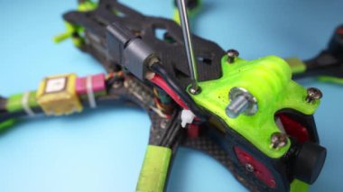 El yapımı bir erkek tornavidanın fpv monte edilmiş bir dronu masasında sökmesini. Yüzeyin derinliği. Düzüşmek ve düzüşmek.
