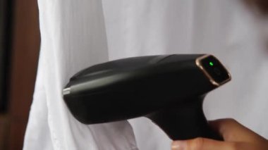 Genç bir kadın, karanlık bir odada beyaz bir adamın gömleğini buharlı ütülüyor. Demir yerine buharlı gemi kullanmak..