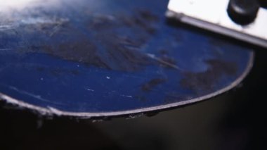 Bir kadın eli, kaygan bir snowboard yüzeyinden fazla balmumu kazıyor. Kayak malzemeleri bakım atölyesi. Yakın plan. Sığ alan derinliği