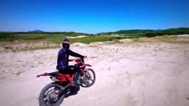 FPV İHA 'dan hava görüntüsü. Profesyonel bir motokrosçunun FMX motosikletini sürdüğü bir sonraki fotoğraf..