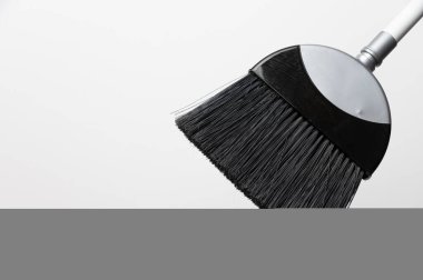 Gri arkaplanda yer süpürgesi sapının kırpılmış görüntüsü, temizleme ögesinin yakın çekimi.