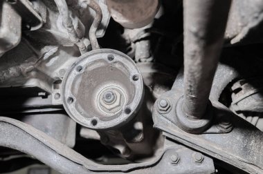 Arabanın altından yakın çekim görüntüsü. Bir off-road aracının kirli süspansiyonu. Aktarım bileşenleri.