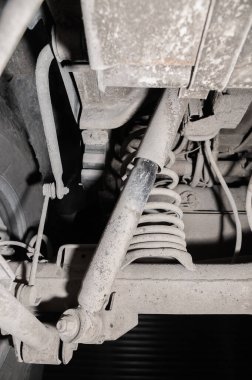Arabanın altından yakın çekim görüntüsü. Bir off-road aracının kirli süspansiyonu. Aktarım bileşenleri.