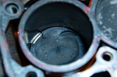 Parçalanmış içten yanmalı bir motor. Motor bloğunda karbon birikintileri ve kırık metal parçaları olan kirli pistonlar var. Araba bakımı eksikliği ve zamansız motor servisi kavramı