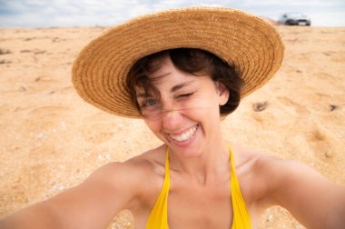 İyi görünümlü kadın turist çekim yakından serbest zaman açık okyanus plaj yakınındaki sahiptir, güneşli yaz gününde, pozlar selfie için eğlence sırasında kameraya benziyor. Tropik mutlu gülümseyen turist.