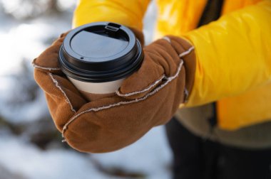 Kahve kadının elinde. Tek kullanımlık kağıt bardakları yakın çekim için. Lezzetli sıcak içecek Glogg içki sokağı.