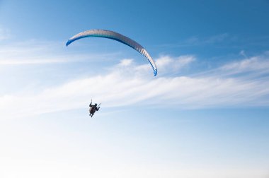 Paragliding sporu, bulutlar, özgürlük ve yalnızlıkla mavi gökyüzünde tek başına uçan bir adam. Yetişkinler için hobi.