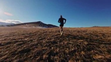 Atletik güçlü, sağlıklı, beyaz erkek sporcu. Sabır için sabahın erken saatlerinde koşuyor. Gün batımında dağlarda kardiyo eğitimi alıyor..