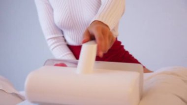 Çarşafları süpüren kadın. Tüm yatakları, kanepeleri ve yatak örtülerini temizlemek için ultraviyole ışığı olan elektrikli süpürgeler ve mikroplu toz akarları. Sağlık hizmetleri konsepti ev temizliği ve sağlık.