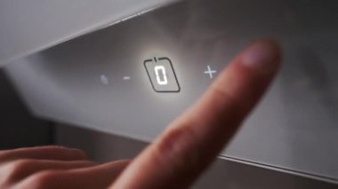 Adam yeni modern mutfak hood kontrol paneli üzerindeki düğmeleri presler