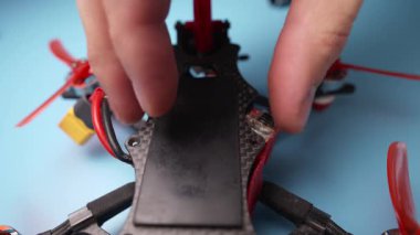 Tamir için kendi kendine monte edilmiş bir FPV İHA 'yı söküyorum. Quadcopter tamir ediliyor. Üst karbon çerçeve kapağı kaldırılıyor