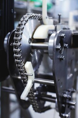 Taşıyıcı ekipman üretiminde paslanmaz çelik üretim elementleri. Zincirli gelecekteki üretim sistemlerinin metal parçaları.