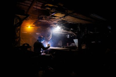 Araç ve kıvılcım kullanan kaynakçılar, garajda kaynak işlemi, koruyucu giysi ve miğfer araçları, yetişkinler için hobi.