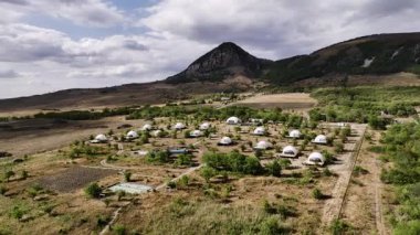 Dağın eteğindeki yeşil bahçeli kubbe otel kompleksi. Rahat bir açık hava tatili için cambazlık yapıyorum..