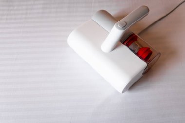 Ev hanımı beyaz yastıkları elektrikli süpürgeyle süpürürken, yakın plan..