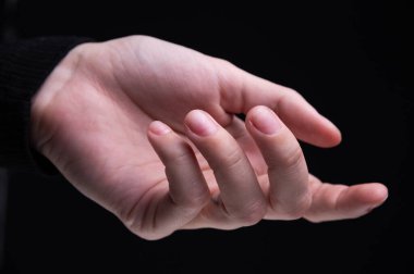 Siyah arka planda tırnaklarında pembe manikür olan güzel kadın elleri. El bakımı, manikür ve güzellik tedavileri. Zarif ve zarif elleri ve ince parmakları var..