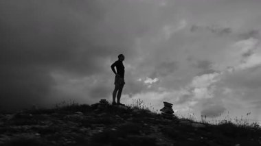 Yoğun bir çalışmadan sonra bir koşucu yoğun bir çimenlikte duruyor. Düzenli egzersiz inanılmaz sonuçlar almanıza yardımcı olacaktır. Uzun mesafe koşusu sırasında dinlenin..