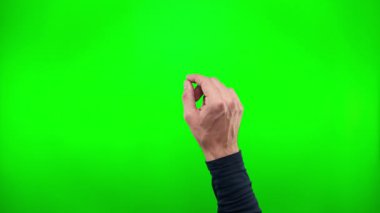 Sahaya girerken işaret eden bir el, parmaklarını açarken yakınlaşıyor ve çerçeveden yeşil bir ekrana doğru çıkıyor..