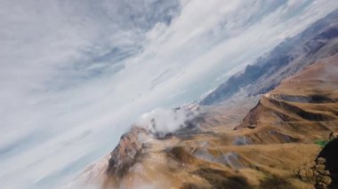 FPV uçaklarının dağ manzarasıyla çevrili destansı keskin kayaların yanında uçtuğunu gören ilk kişi..