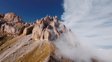 Uçan paraglider ya da uzaktan kumandalı kanat ya da bulutların içindeki İHA parlak bir günde kayalık sarı dağlarda kuş bakışı arazi kuşları.