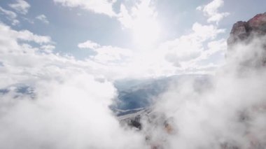 Hava manzaralı sinemalar bulutların arasında süzülür. Alçak bulutlar, destansı dağlık arazide kaya oluşumlarında yatar. Fpv İHA görüntüsü