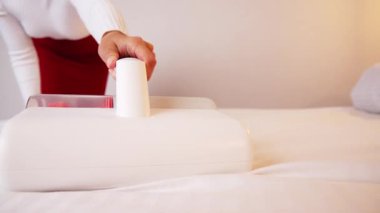 Çarşafları süpüren kadın. Tüm yatakları, kanepeleri ve yatak örtülerini temizlemek için ultraviyole ışığı olan elektrikli süpürgeler ve mikroplu toz akarları. Sağlık hizmetleri konsepti ev temizliği ve sağlık.