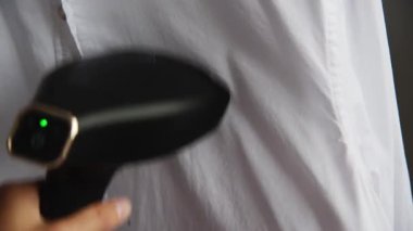 Yakın plan beyaz gömlekli, taşınabilir taşınabilir buharlı genç bir kadın. Ev hayatı ve rutin şeyler. Giysi bakımı.