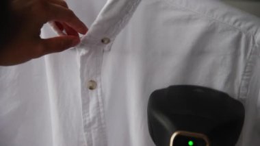 Genç bir kadın, karanlık bir odada beyaz bir adamın gömleğini buharlı ütülüyor. Demir yerine buharlı gemi kullanmak..